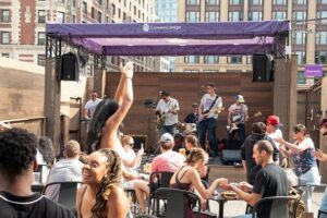 The outdoor crowd cheers for the Roland High Life during a live performance at the Emerson College Uncommon Stage in Boston, Massachusetts